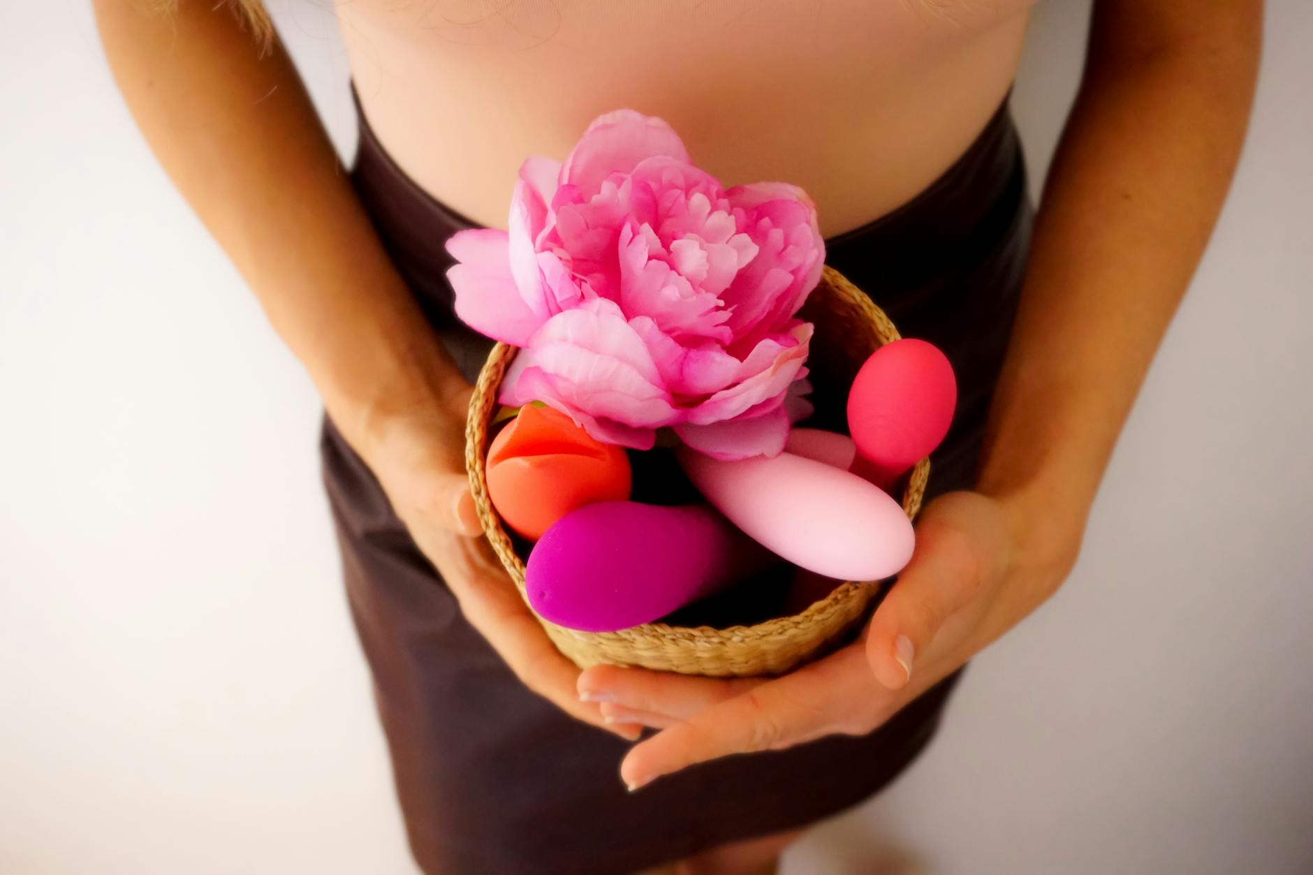 Three colorful vibrators arranged on white fabric, highlighting their smooth texture.